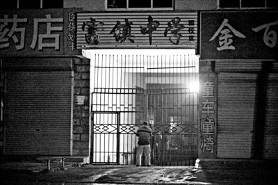 昨晚，富镇一中大门紧锁。5月22日，两名男子闯入该校初中女生宿舍，涉嫌强奸6名女生。新京报记者 周岗峰 摄