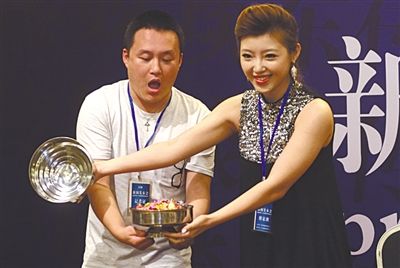  魔术师王璐和现场一位记者表演“空盆出彩”。