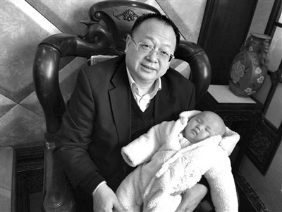 罗志元（左）抱着一个女婴。微博截图