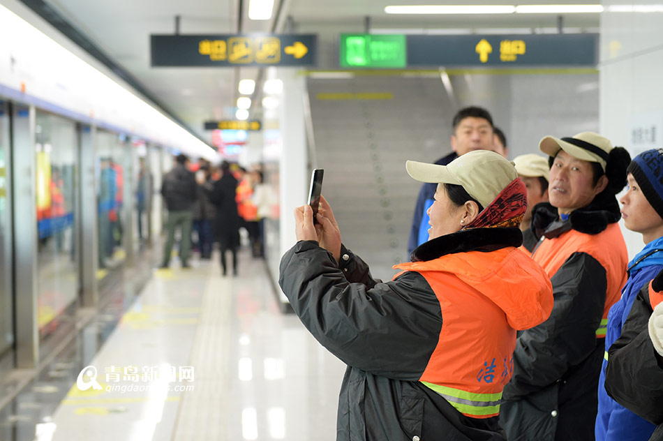 高清:500多名环卫工人试乘地铁 手机拍个不停