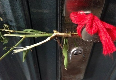 邻居门上绑着辟邪的红绸布和桃树枝